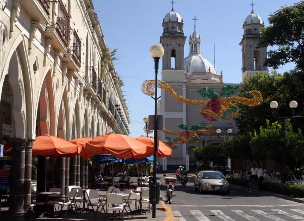 A lively outdoor café near Colima’s central plaza, showcasing the city’s relaxed atmosphere and beautiful colonial arches.